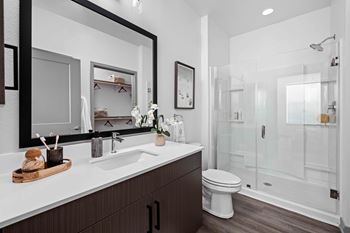 A modern bathroom with a white sink and a white toilet at The Quinn Luxury Apartments, Florida